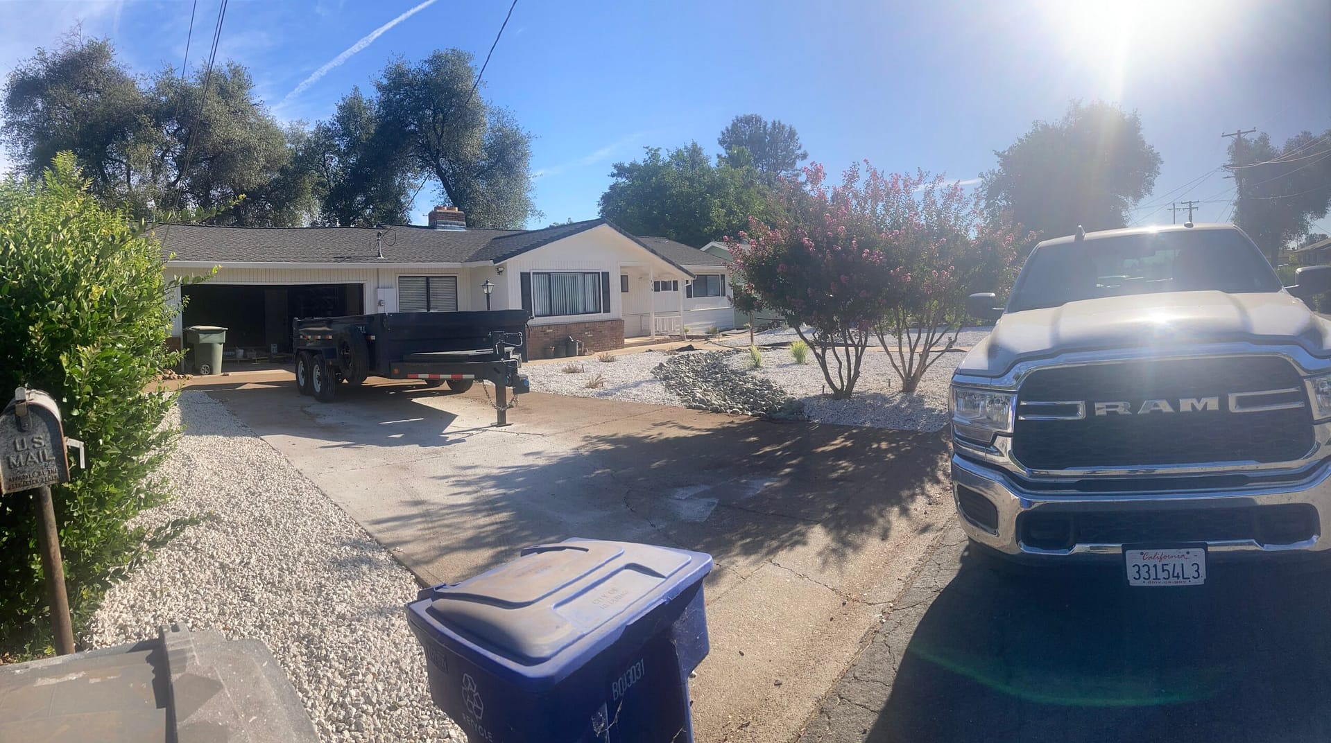 Residential exterior remodeling project showing a single-story home, driveway, and construction equipment during renovation by On Point Construction.