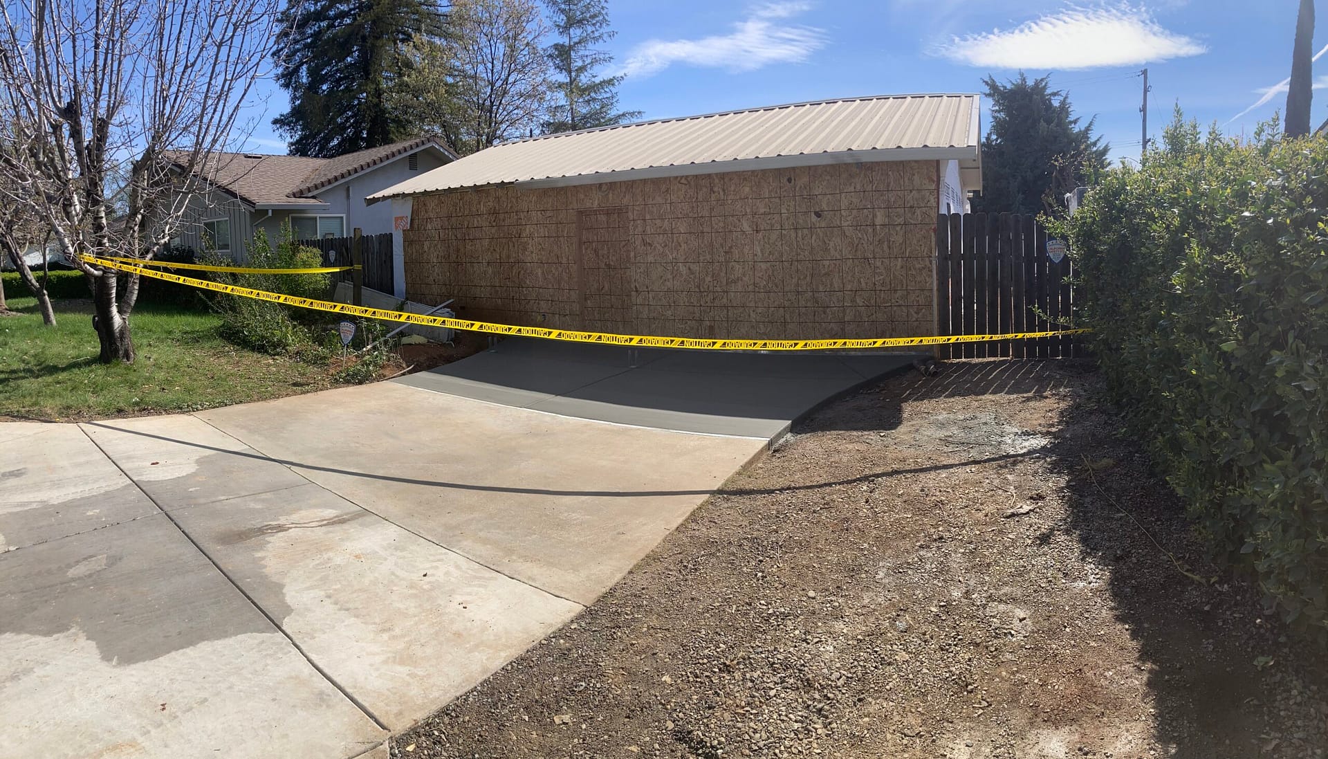 New concrete driveway pour with freshly finished concrete slab and existing driveway connection by On Point Construction.
