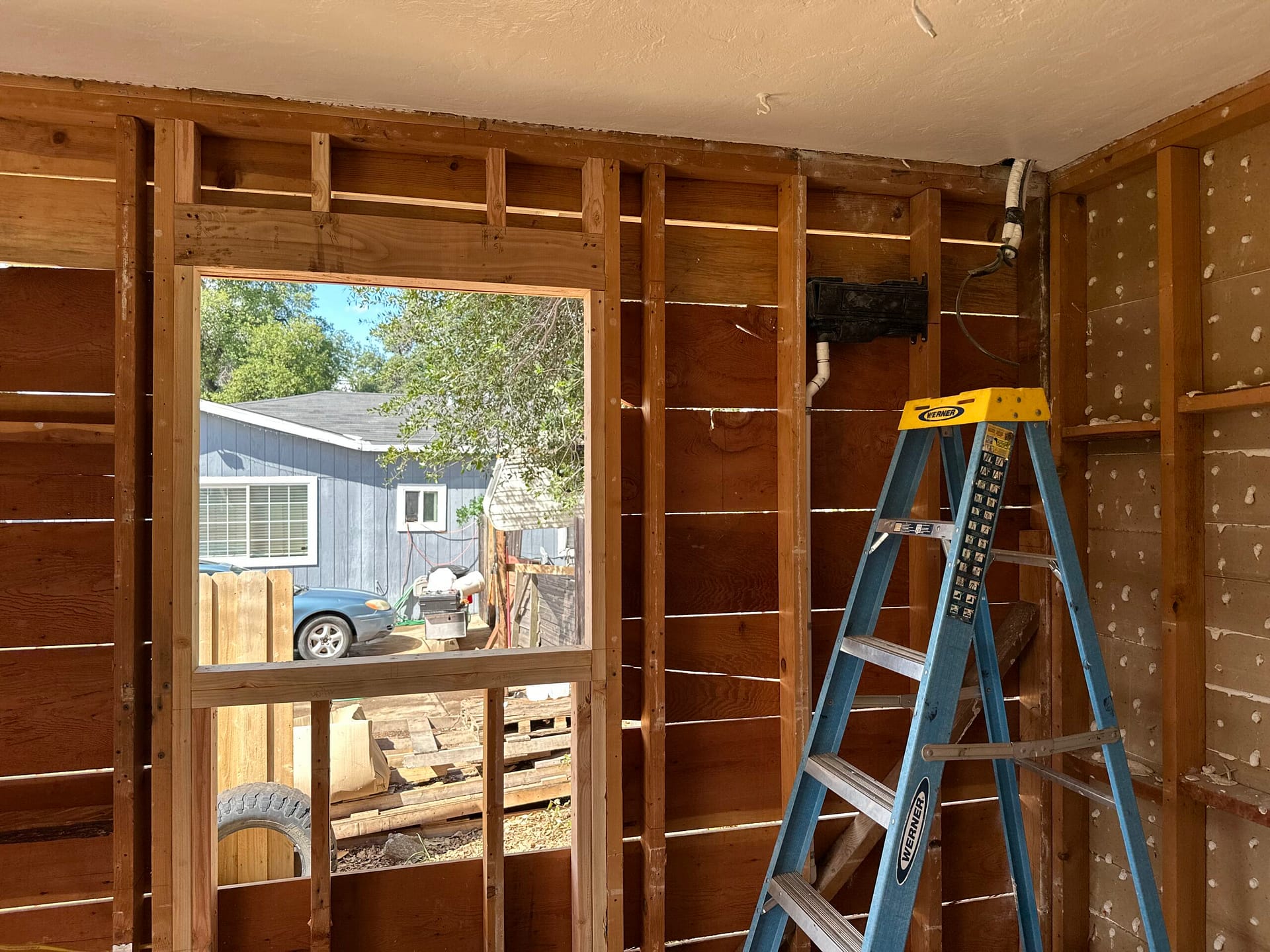 Window addition framing in progress with a new rough window opening, exposed wall studs, and interior remodeling by On Point Construction.
