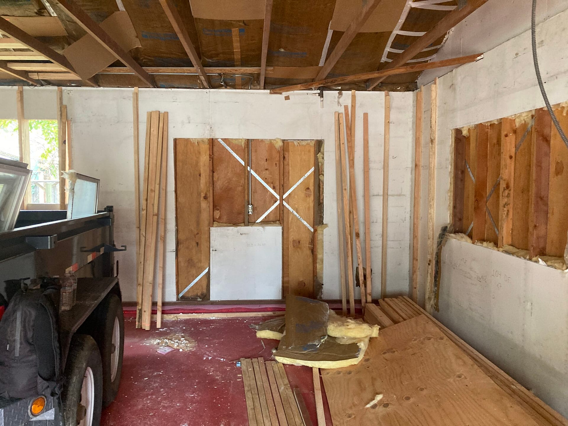Interior demolition during residential remodeling showing exposed ceiling joists, opened wall sections, and framing preparation by On Point Construction.