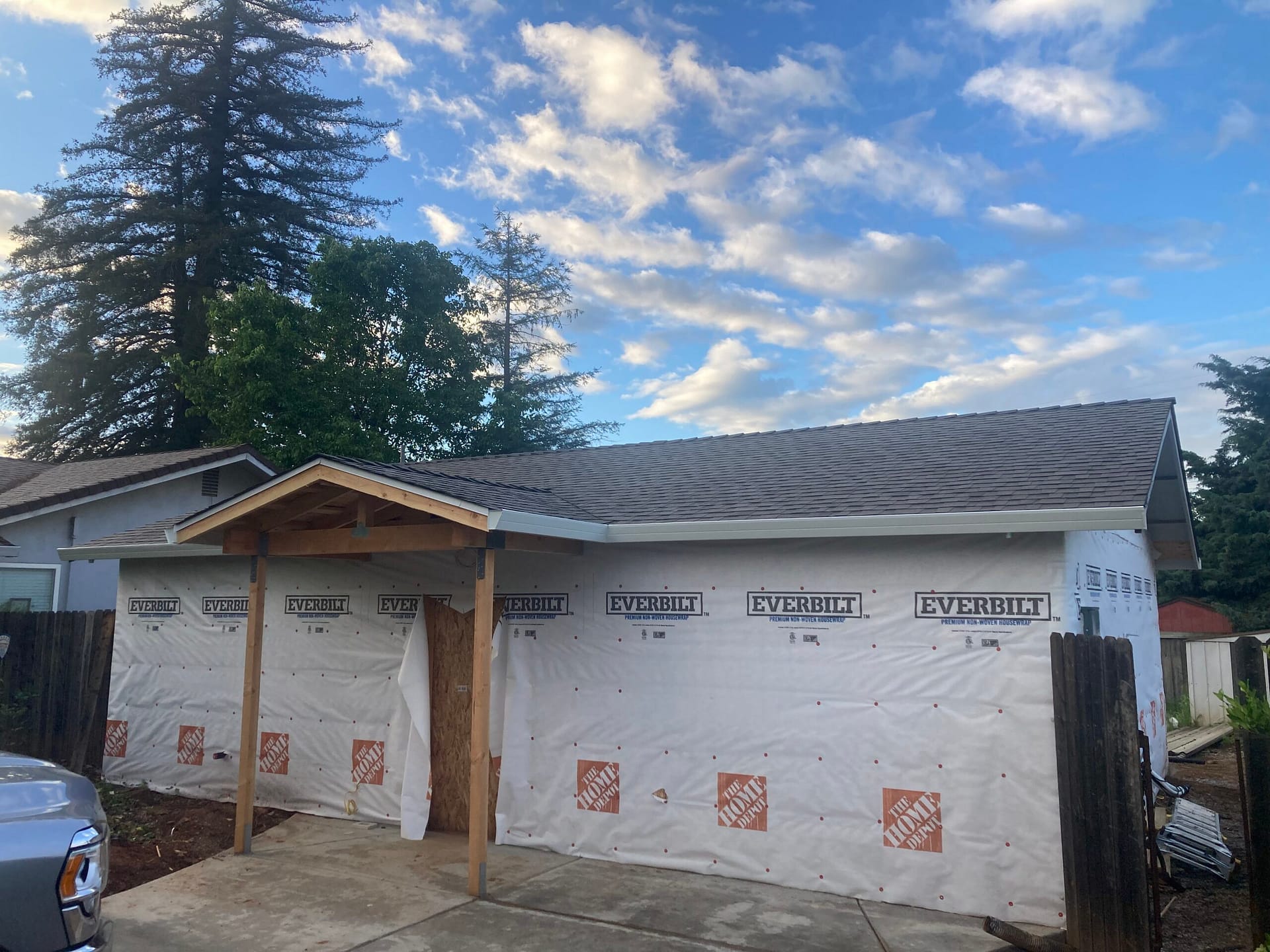 Exterior siding installation preparation with house wrap, weather barrier, and newly framed covered entry porch by On Point Construction.