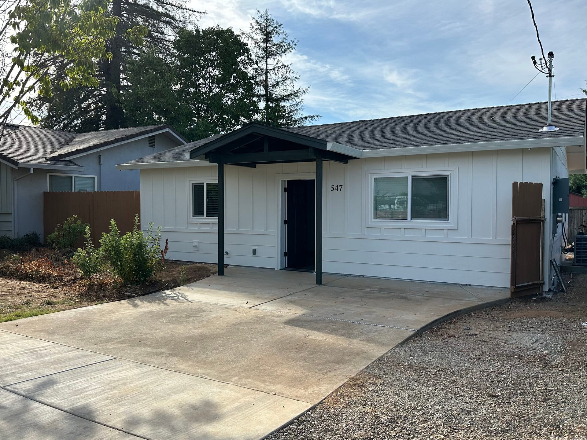 Completed garage-to-ADU conversion exterior with new siding, windows and a covered entry.
