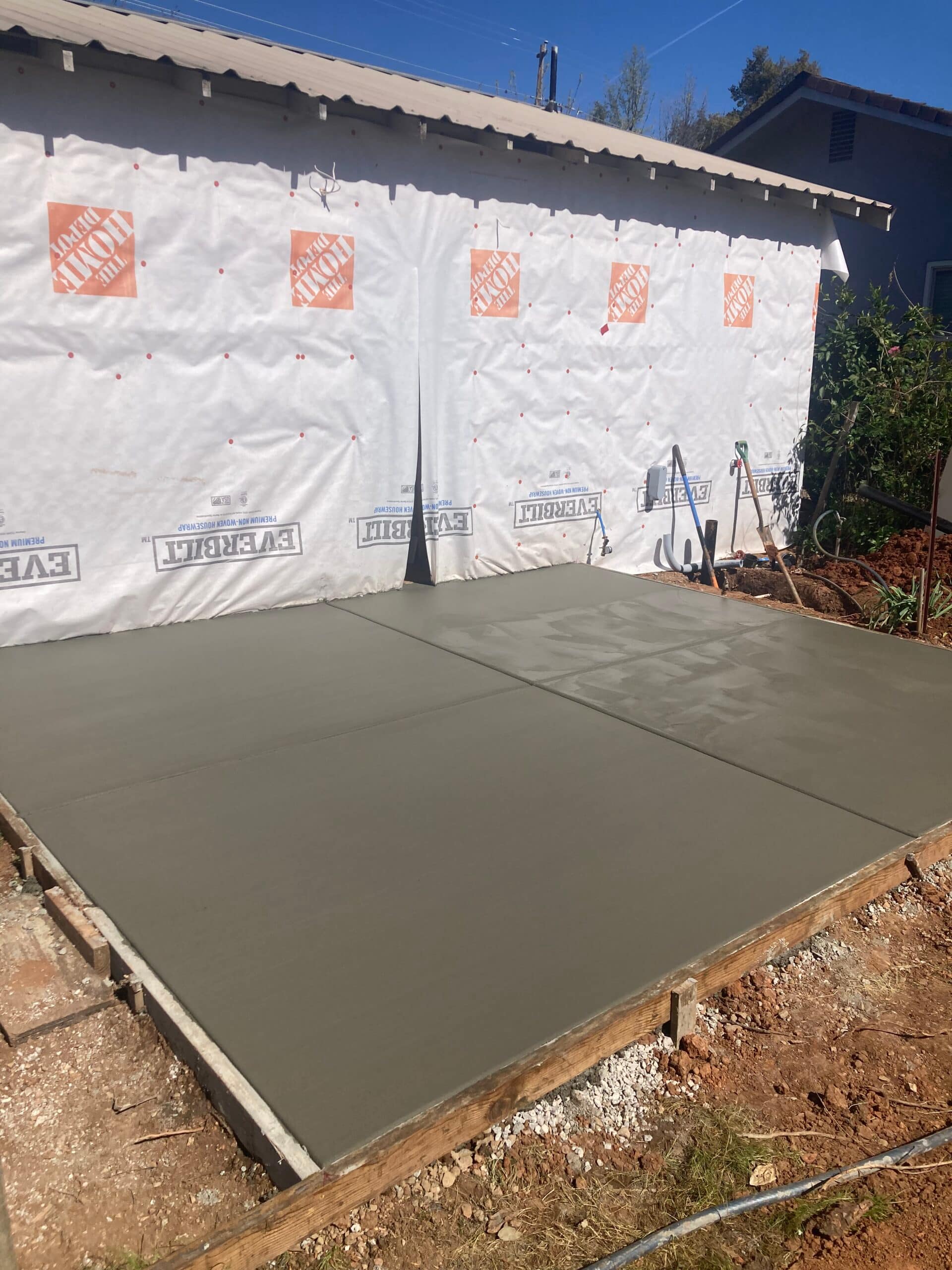 New back patio concrete pour with freshly finished concrete slab by On Point Construction.