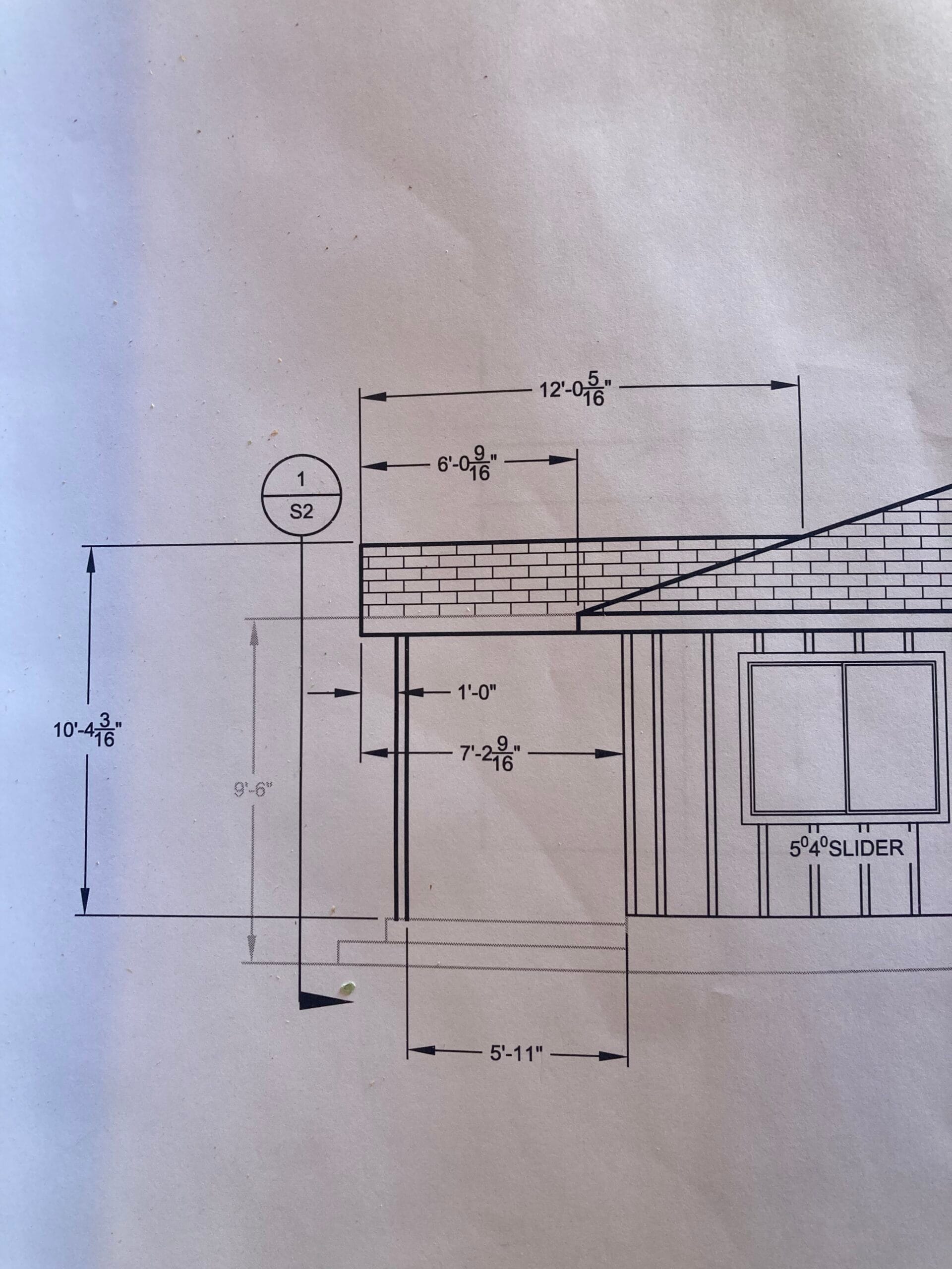 Architectural elevation drawing with window opening, roof line and measurements for exterior wall framing.