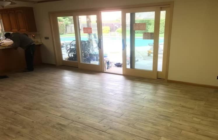 Completed double glass patio doors opening from a remodeled interior to a backyard.