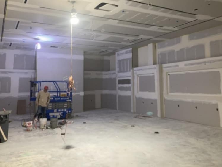 Commercial buildout in progress with drywall finishing and interior construction work underway
